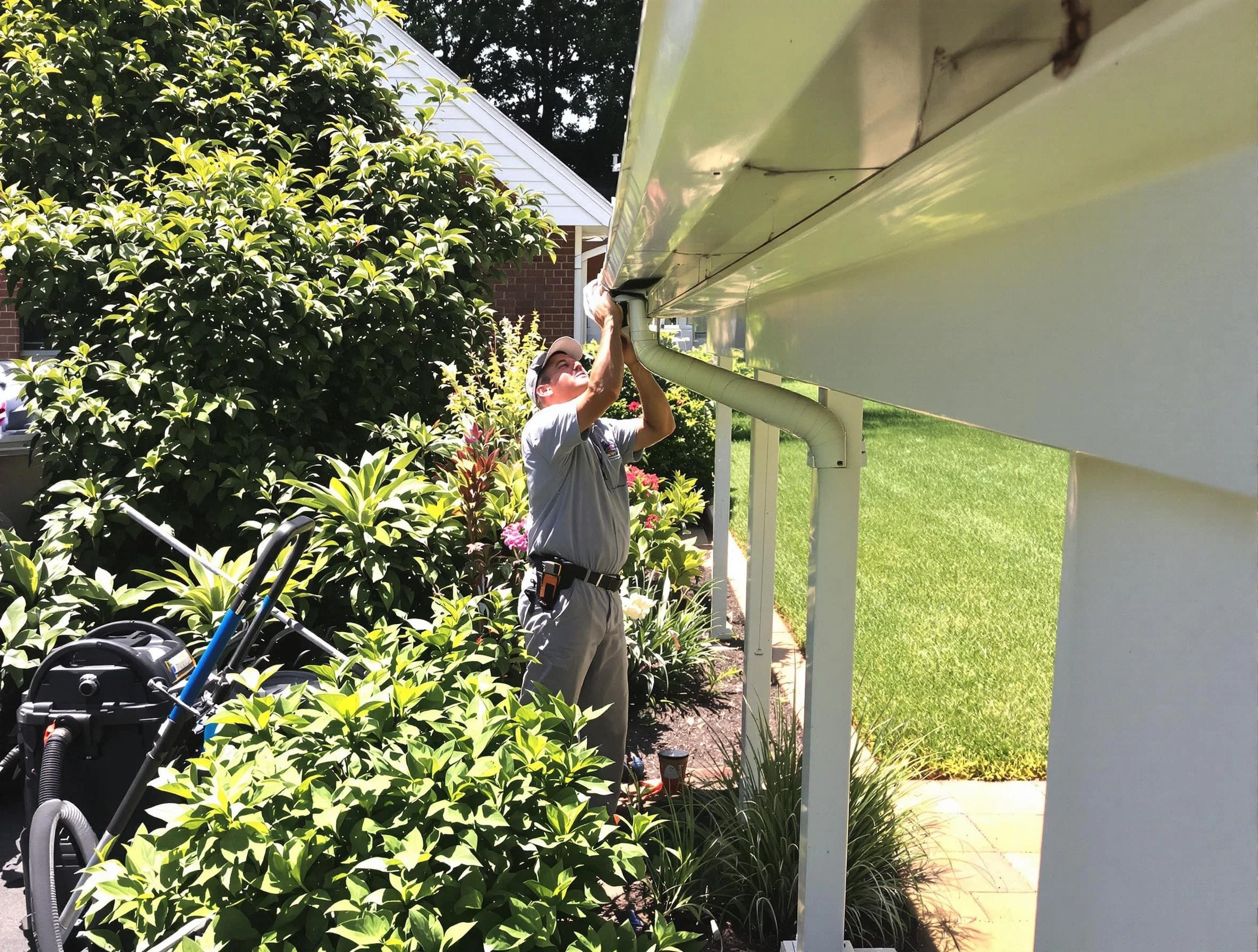 Technician flushing a blockage from a downspout in North Olmsted, OH